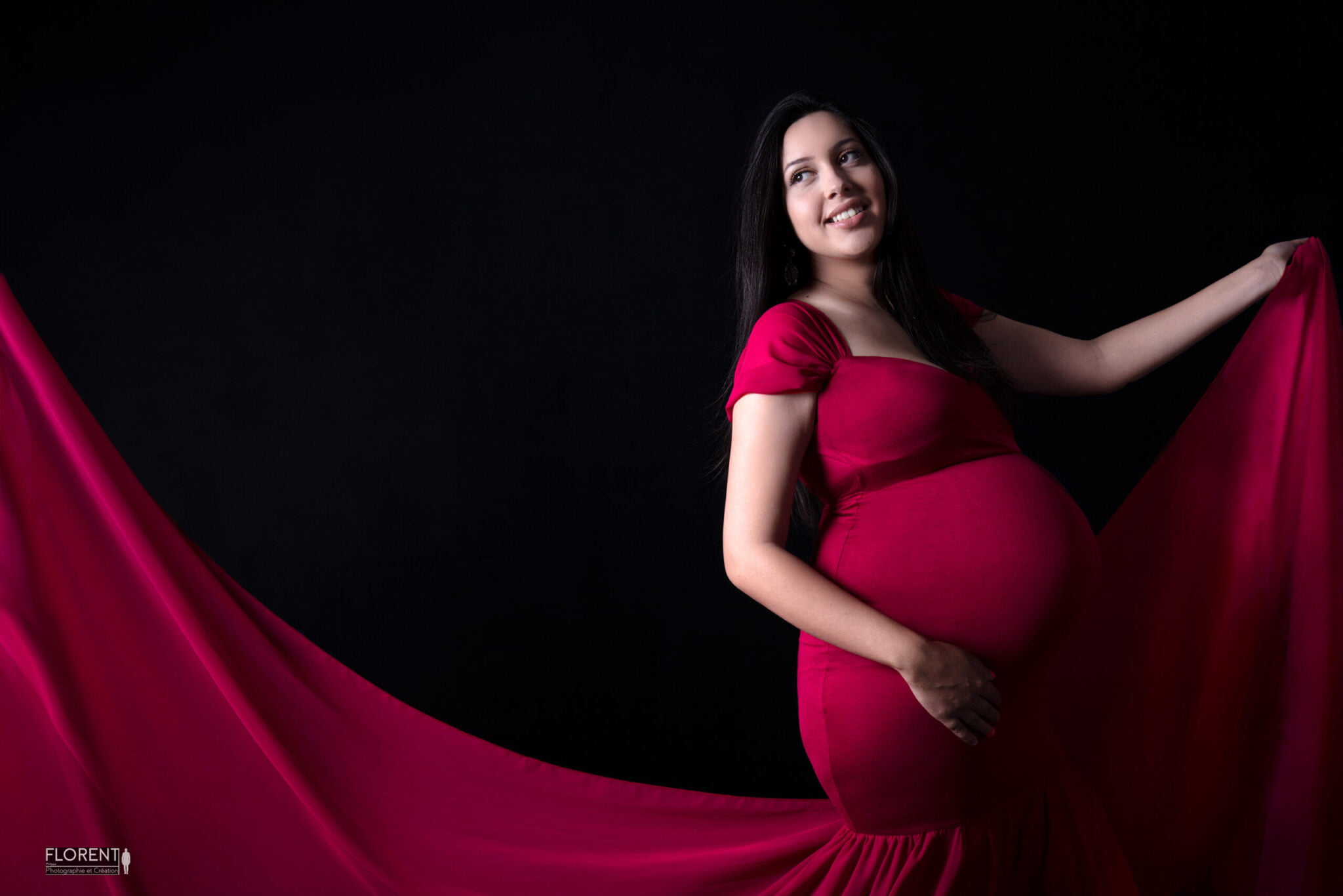 photographe maternité d'une maman souriante avec sa robe rouge dans le vent studio photographe florent boulogne sur mer lille paris