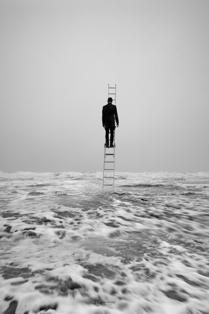un homme au milieu de la mer en tempête au sommet d'une échelle se bat contre les vents photo créative noir et blanc florent boulogne sur mer lille paris calais