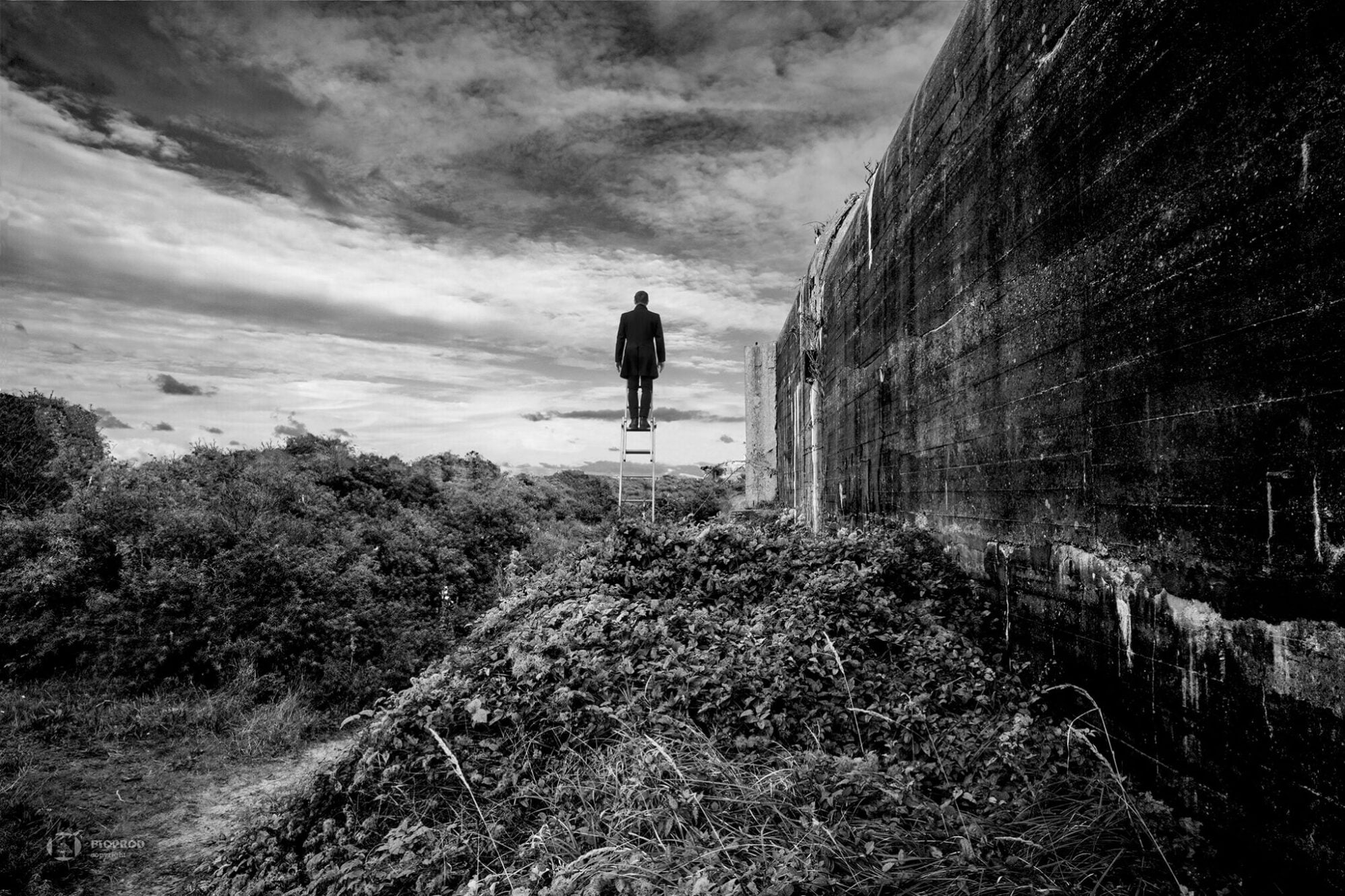 photo art en noir et blanc calais d'un homme au sommet de son échelle proche d'un blockhaus