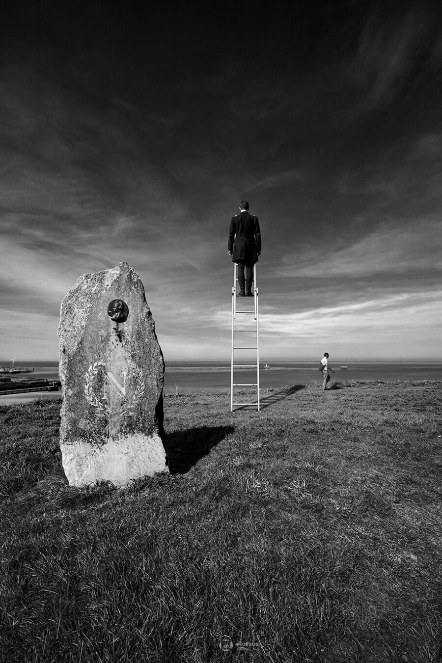 photo art boulogne sur mer photo noir et blanc un homme au sommet d'une échelle face à un phare qui surplombe la mer