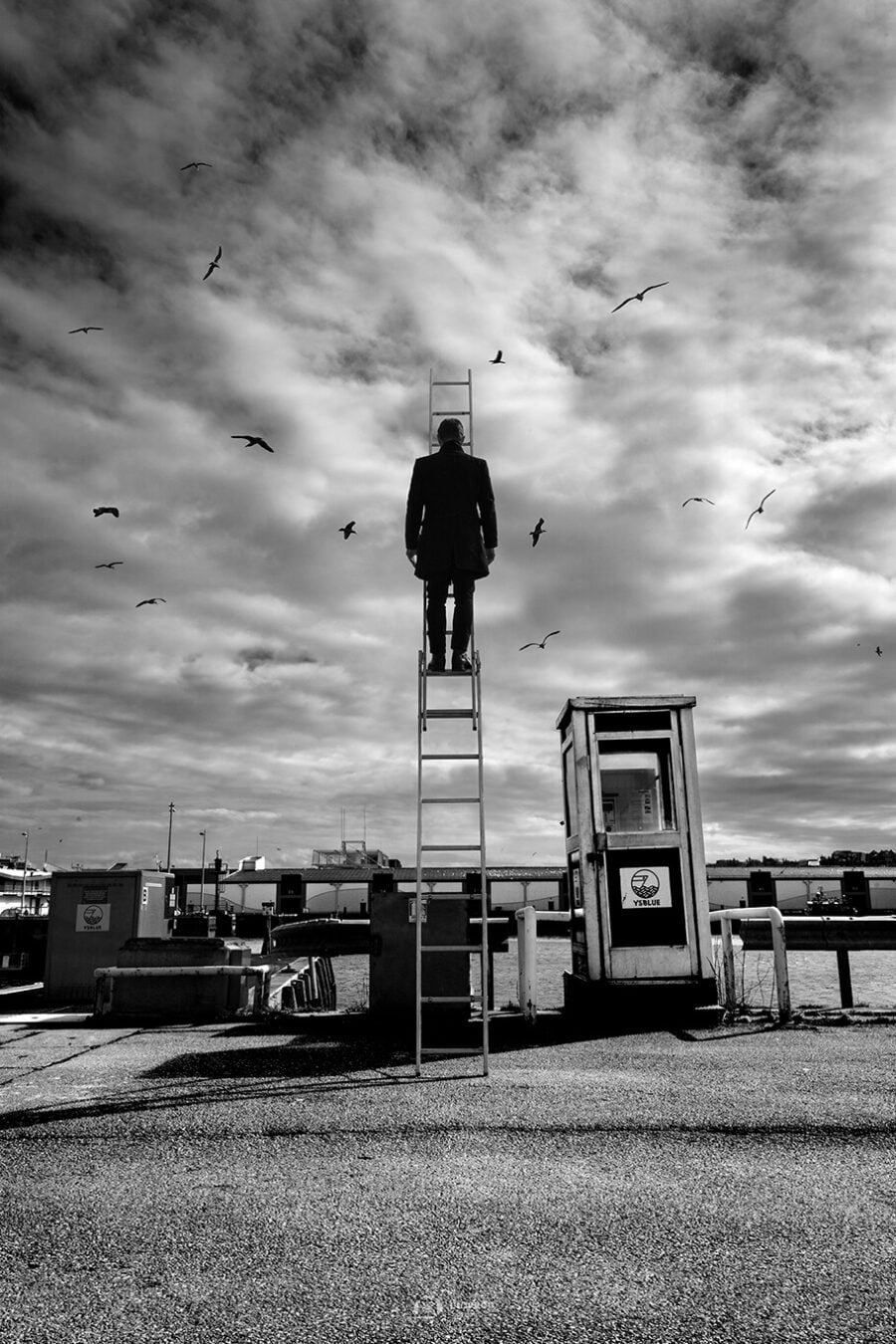 photo port boulogne sur mer art un homme au sommet d'une échelle à coté d'une ancienne cabine téléphonique face aux chalutiers florent photographe