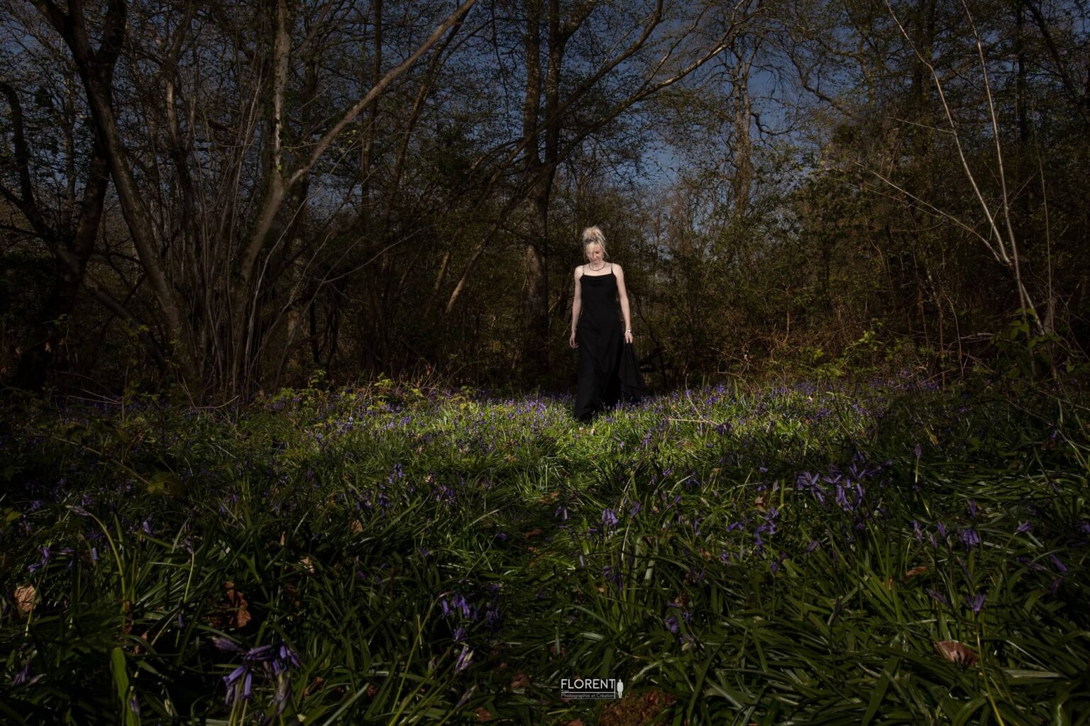 photo florent une femme élégante marche en forêt au lileu des fleurs bleues