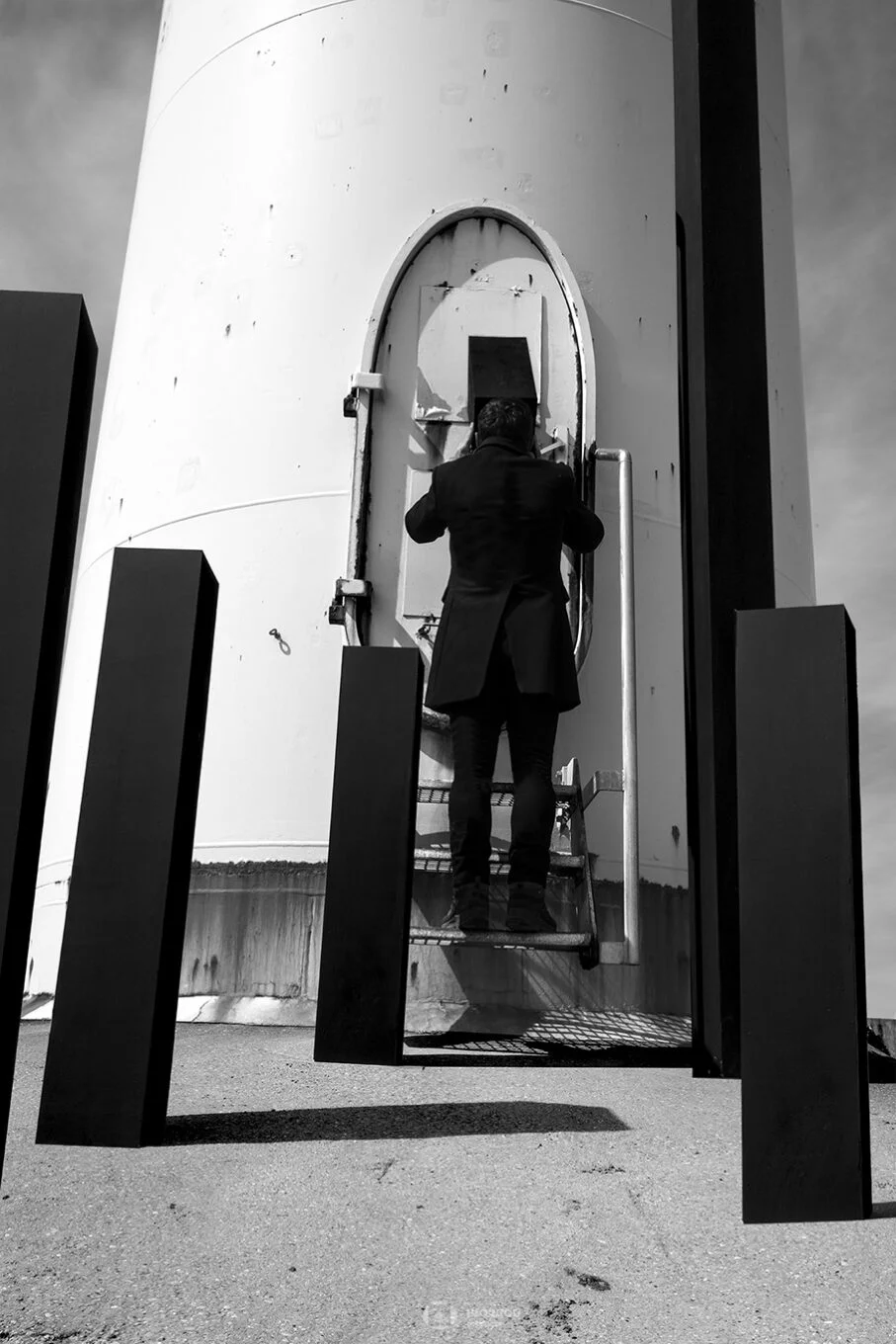 photo art boulogne sur mer un homme observe l'intérieur d'une éolienne avec ses colonnes noires florent photographe création