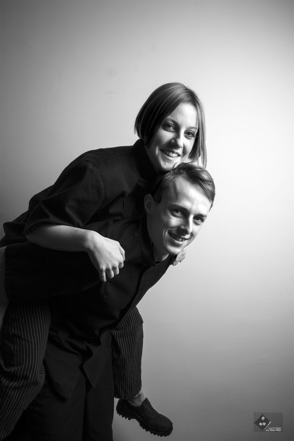 photo amusante en noir et blanc d'un couple montant sur le dos avec un grand sourire florent studio photographe boulogne sur mer