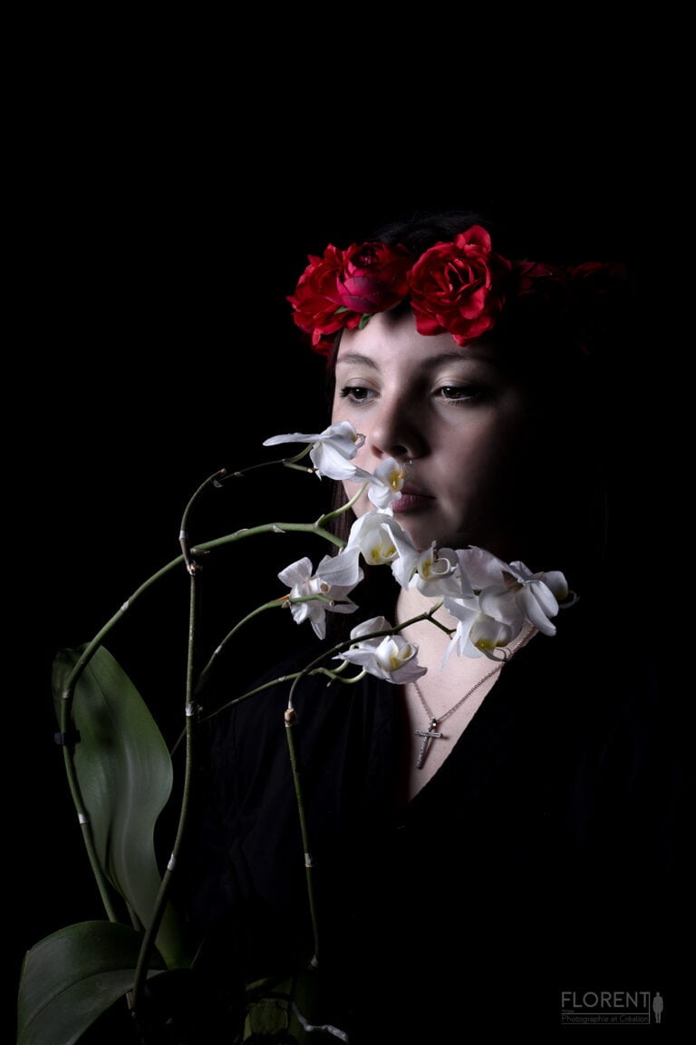 photo studio florent jeune fille avec couronne de fleurs rouges approche délicatement son visage d'une orchidée blanche boulogne sur mer lille paris le touquet calais