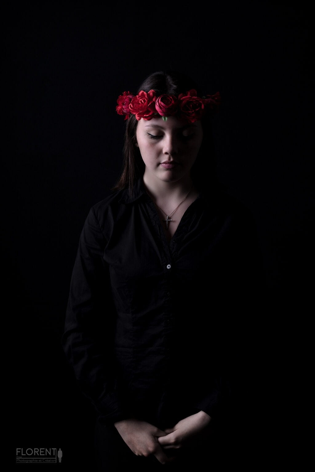 photo book délicate jeune fille sur fonds noir et couronne de fleurs rouges est pensive studio florent lille boulogne sur mer