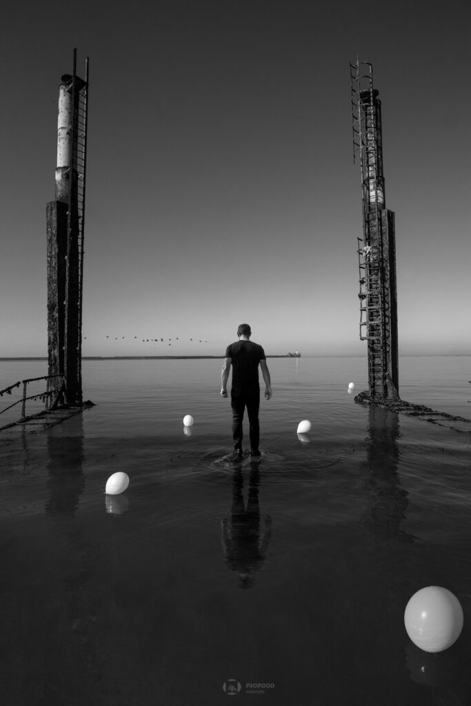 photo art un homme en noir semble marcher sur l'eau entouré de ballons blancs florent studio photographe art boulogne sur mer saint omer paris lille marseille