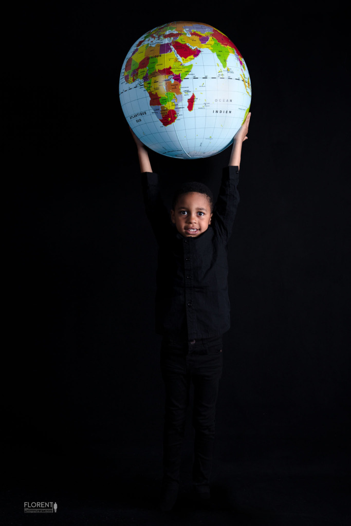 photo famille avec pour thème la planète avec ce jeune garçon qui envoie son ballon mappemonde studio Florent Boulogne sur mer