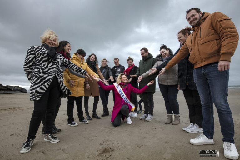 photographe anniversaire en bord de mer joyeuse famille et amis se tiennent la main au dessus de miss 40 studio florent photographe boulogne sur mer lille le touquet paris Calais