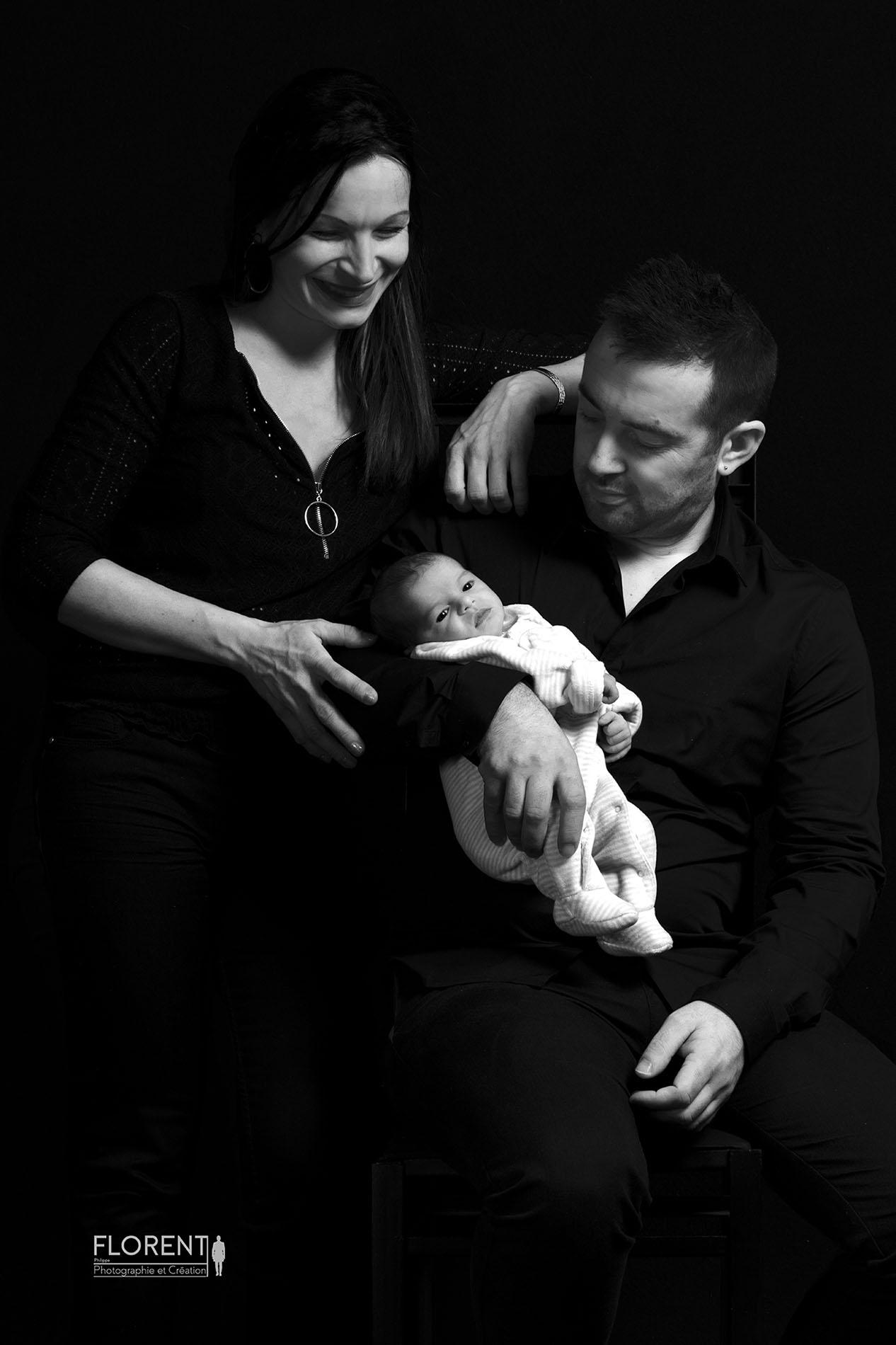 superbe portrait en noir et blzanc de bébé dans les bras de maman et papa en studio florent p^hotographe boulogne sur mer lille le touquet paris amiens