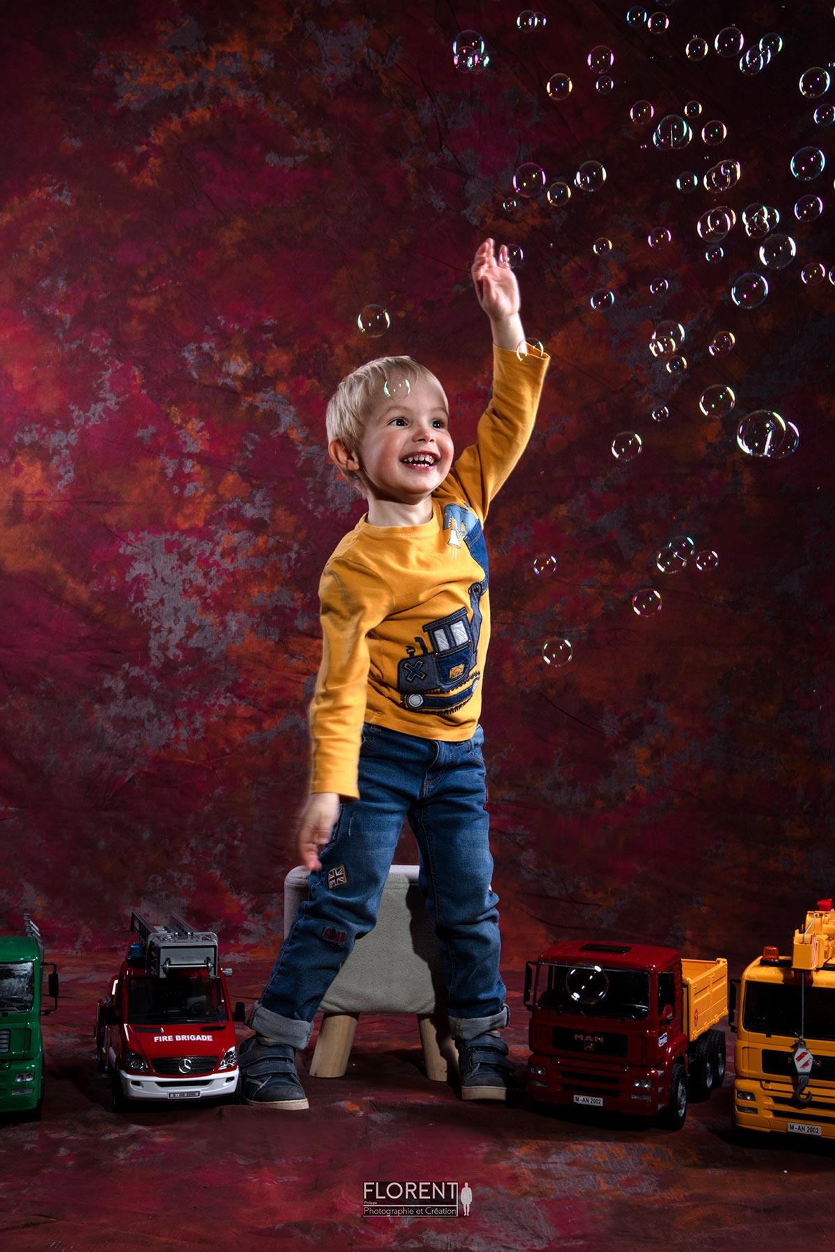 enfant au mileu des jouets joue avec des bulles souriant florent photo boulogne sur mer lille le touquet paris calais amiens