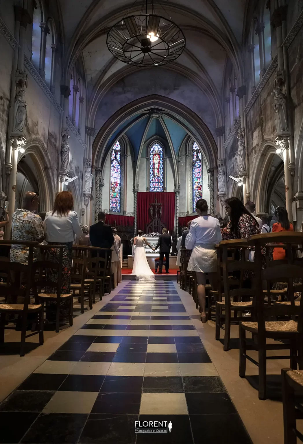 Les maries au loin main dans la main dans le coeur de la cathedrale photographe fanie florent boulogne sur mer lille le touquet paris saint omer