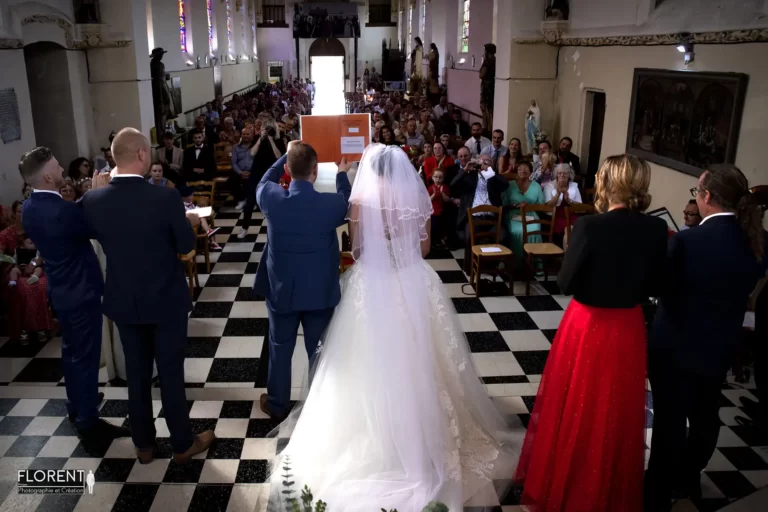 mariage lille les mariés dos à l'autel de l'église levent le livre devant l'assemblée en joie florent studio boulogne sur mer le touquet paris saint omer