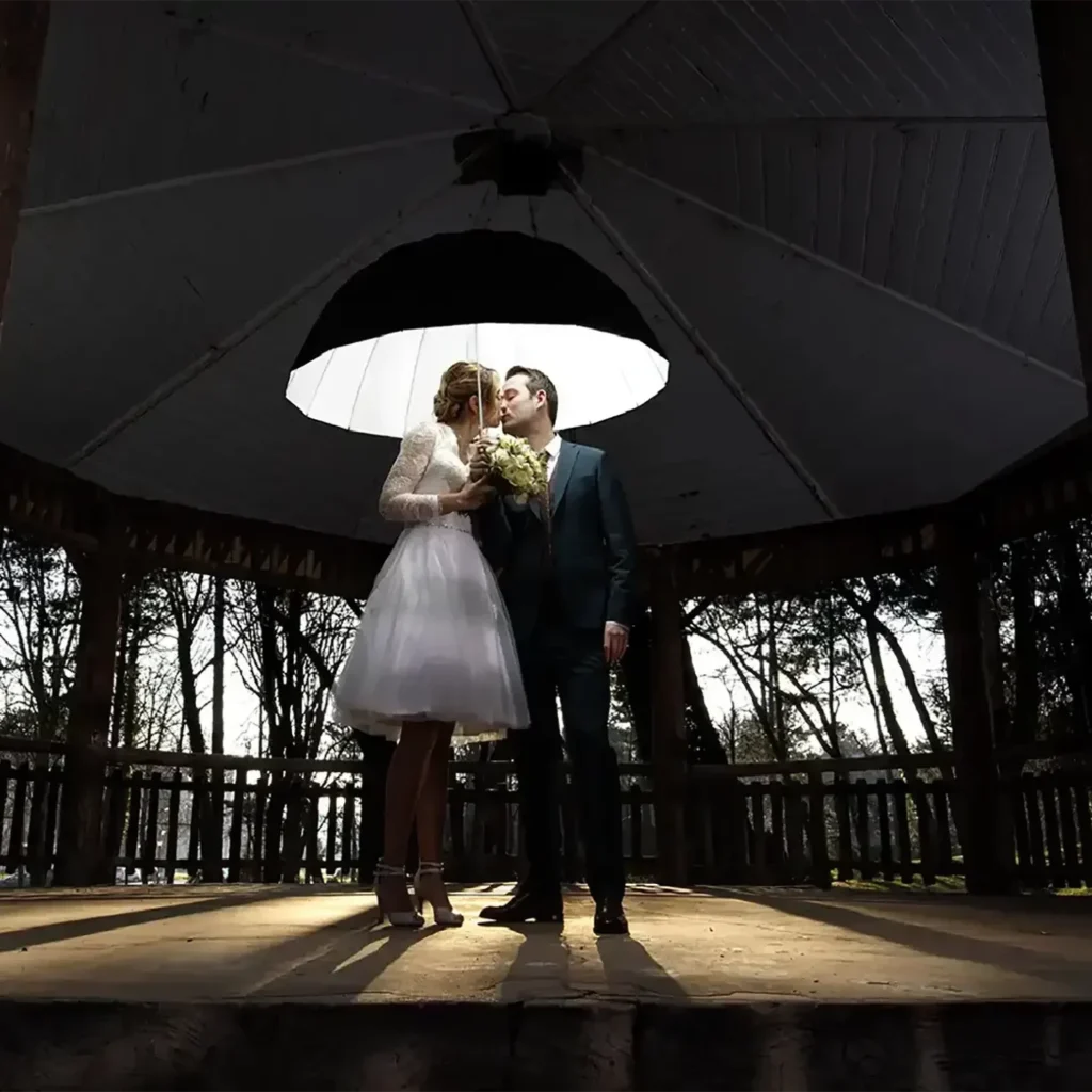 photographe mariage sous le kiosque s'embrassent sous le parapluie lumineux florent studio lille paris boulogne sur mer saint omer