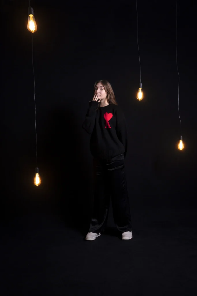 book photo jeune femme comedienne joue sur fond noir avec ampoules suqpendues humour florent studio boulogne sur mer lille le touquet paris calais saint omer dunkerque lens