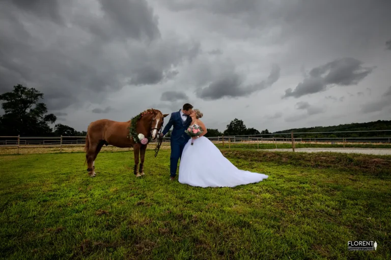 mariage-saint-omer-superbe-photo-les-maries-sembrasse-avec-leur-cheval-sous-la-pluie-au-milieu-du-manege-studio-photographe-mariage-pas-de-calais-nord-boulogne-sur-mer-lille-paris-arras-calais