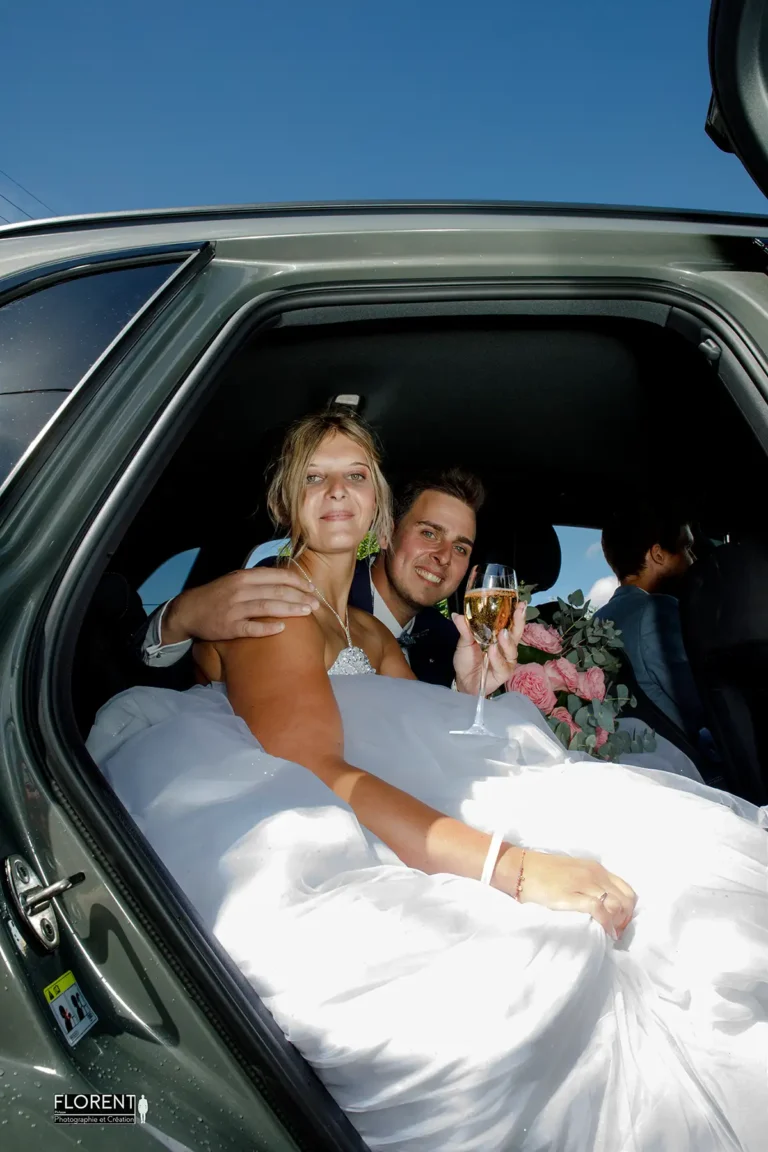 photographe-mariage-saint-omer-les-maries-souriants-dans-la-voiture-avec-coupe-de-champagne-studio-photographe-mariage-pas-de-calais-nord-boulogne-sur-mer-desvres-lille-paris-arras-le-touquet