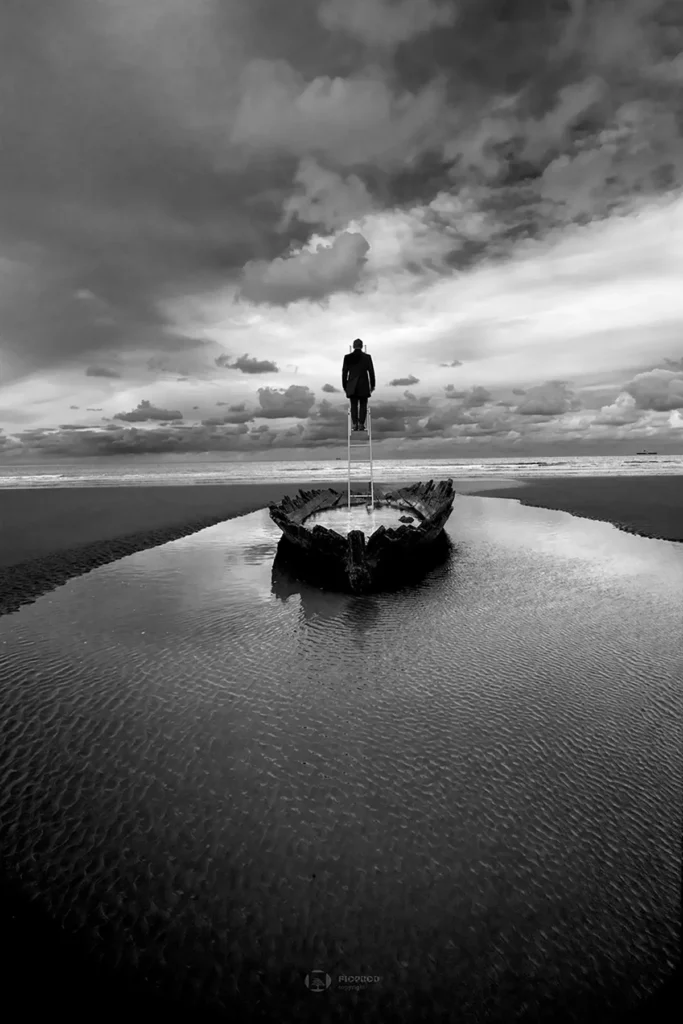 Escape-19-photo-noir-et-blanc-artistique.-Homme-sommet-echelle-dans-une-barque-echouee.-Boulogne-sur-mer.-Florent