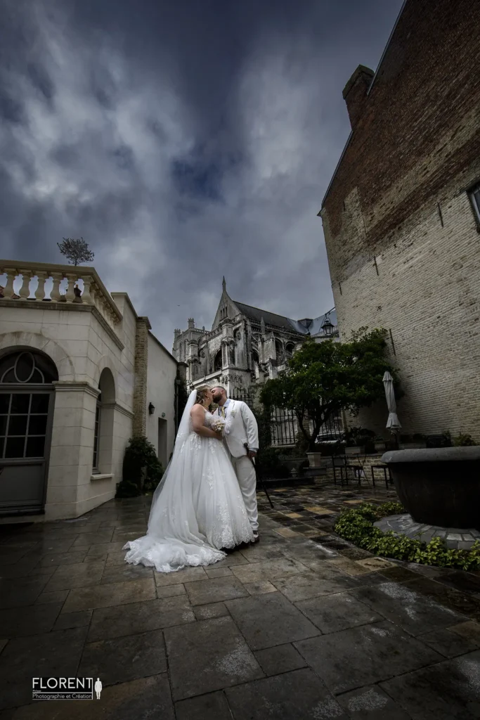 mariage epoux s embrasse sous la pluie saint omer vue sur la cathedrale clos bailli florent studio